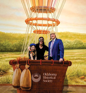 A family gathers in the basket of a hot air balloon for a photo op.