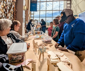 Volunteers helping children at craft tables