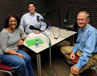 Executive Director Trait Thompson, Dr. Bob Blackburn, and Dr. Sunu Kodumthara are seated at a table with microphones