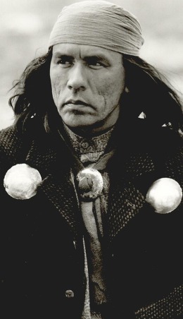 Actor Wes Studi, a Cherokee actor dressed in heavy coat and layers, with metal medallions on the movie set of 'Geronimo.'