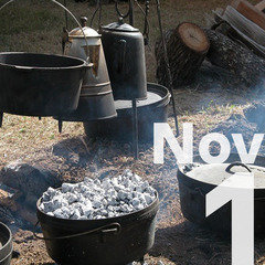 Dutch ovens heaping with coals cooking over an open fire