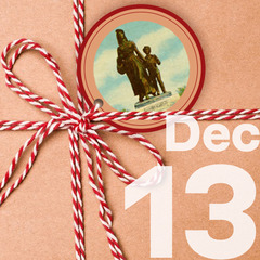 A craft paper package tied with a string bow and a gift tag with a photo of the Pioneer Woman Statue in Ponca City.