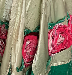 A fan with a picture of Booker T. Washington, Collection boxes, a 1930s brass doorknob and backplate, and an evening gown with large rose appliques