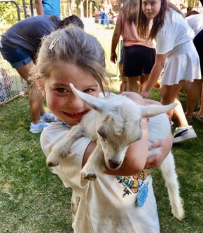  A young girl holds a baby goat at a petting zoo at the Cherokee Strip Regional Heritage Center Family Farm Day activities.