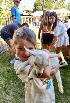  A young girl holds a baby goat at a petting zoo at the Cherokee Strip Regional Heritage Center Family Farm Day activities.