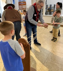 Children learn the art of rope making with volunteer help at the Will Rogers Memorial Museum.