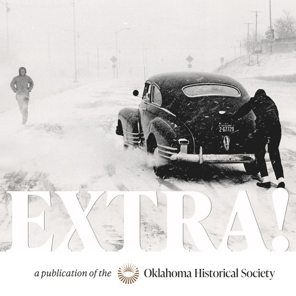 Blizzard conditions swirl as a pedestrian walks along a city street where another man is pushing a car out of a slick spot in the road.