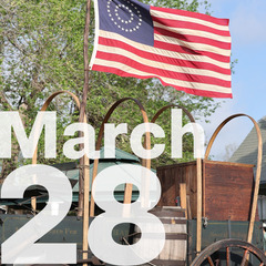 An American flag flying above a chuckwagon and the Date March 28