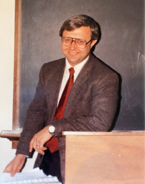 Dr. Timothy Zwink leans on a classroom podium