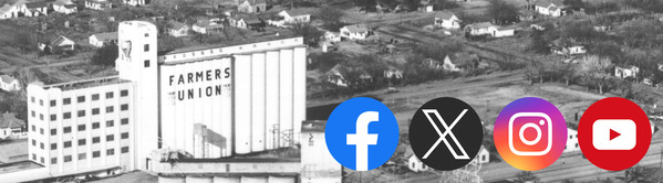 Yukon grain elevators tower above the homes of the town and the Facebook, X, Instagram, and YouTube.