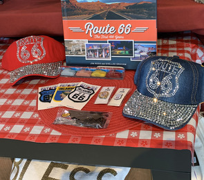 Baseball caps with sequined design of Route 66 logo, Route 66 patches, stickers, and store merchandise about Route 66.
