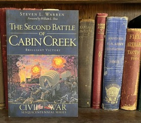 The Second Battle of Cabin Creek, book cover in a shelf with other hardback books with military titles.