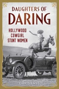 A book cover depicting a cowgirl on horseback jumping over a vintage automobile.