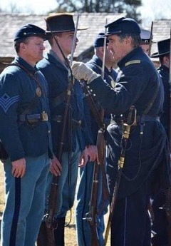 Members of the 24th Missouri Volunteer Infantry volunteers line up for a weapons inspection.