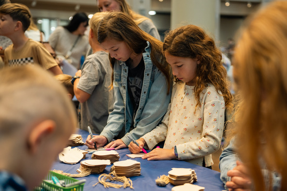 Children gather around a table to create a make-and-take craft project at the Oklahoma History Center