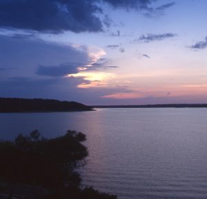 A view of the shoreline at Kaw Lake as a storm approaches at sunset.