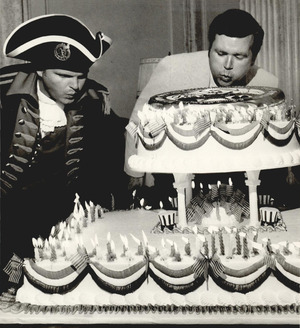 Governor David Boren blowing out 200 candles on a birthday cake with help from Sgt. Joe Morgan, dressed as a Revolutionary War Soldier.