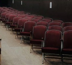Multiple rows of maroon velvet upholstered theatre seats aligned at the Buffalo Theatre in Pawnee.