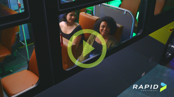 Two women riding on RAPID's vehicle.