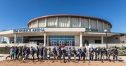 lots of people in a row holding shovels in front of Jim Norick Arena for the MAPS 3 & 4 Coliseum groundbreaking