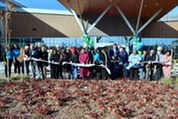 group of people cutting ribbon in front of senior health and wellness center