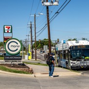 Man waiting to board EMBARK bus infront of Chelsea Manor Apartments.
