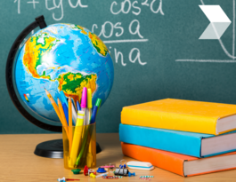Globe books and classroom supplies in front of chalkboard