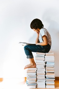 kid reading on a stack of books