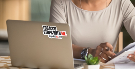Woman with laptop and Tobacco Stops with Me Sticker on back