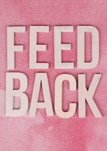 The word feedback on a pink background