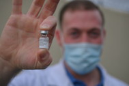 Cameron Schmitt, pharmacist, holding COVID-19 vaccine vial