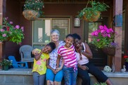 photo of smiling intergenerational family in front of apartment