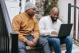 two people looking at a laptop