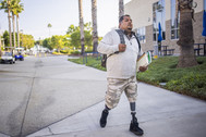 a man with prosthetic limbs carries a backpack