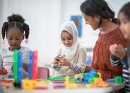 a muslim girl plays with an adult and another girl