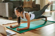 woman-exercising-watching-training-videos-on-laptop