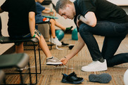 Heart to Soles, man putting new shoes on child 