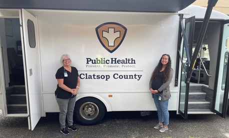 photograph of two women standing in front of a health care van