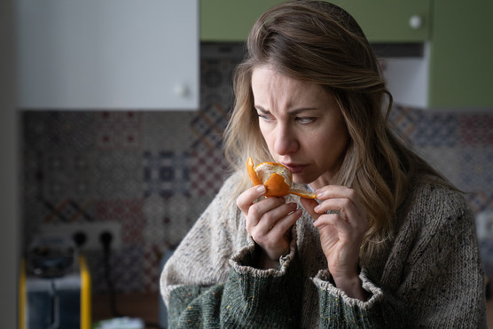 photo of a woman trying to smell an orange