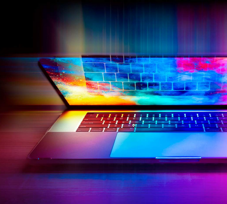 Picture of a computer opened up, with the keyboard reflecting against the screen, which is lit up.