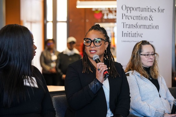 ODHS Child Welfare Director Aprille Flint-Gerner speaks into a microphone as part of a panel during the DDF announcement