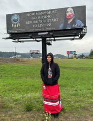 Amanda Freeman stands in front of a billboard she helped create to raise awareness for Missing and Murdered Indigenous People