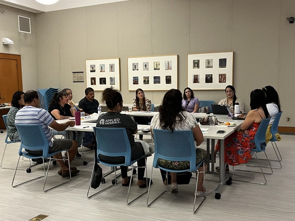 people sit around a table for a customer service focus group in Spanish