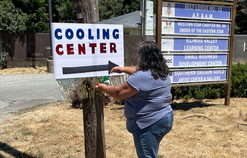 Silvia Ceron puts up a hand made cooling center sign