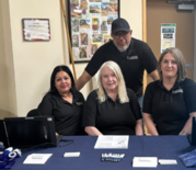 3 women and 1 man wearing black ODHS shirts at a service table