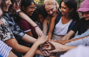 diverse smiling children putting hands together