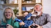 older man and woman playing video games with young boy