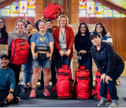 diverse group of people holding batteries and supplies
