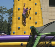child climbing a large yellow rock wall