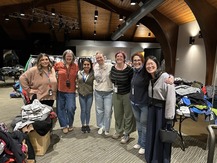 ODHS staff pose together in front of coats set up for the event